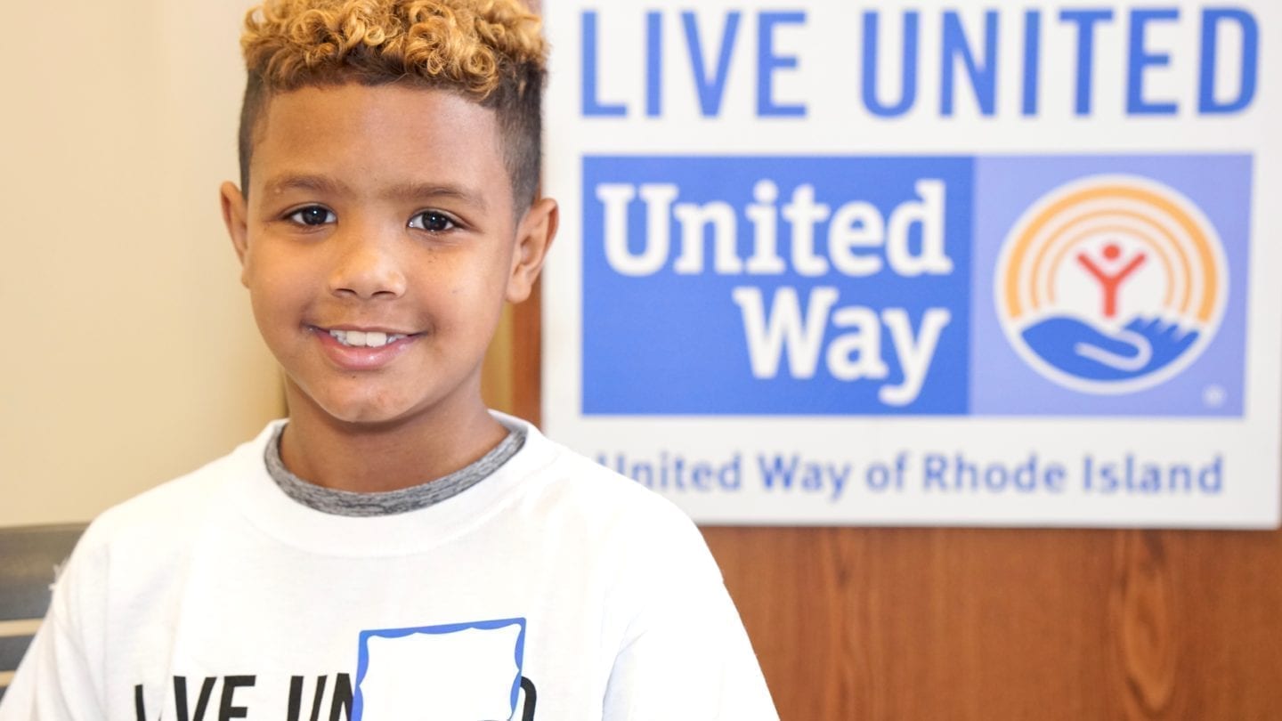 Boy smiling in a United Way of Rhode Island shirt.