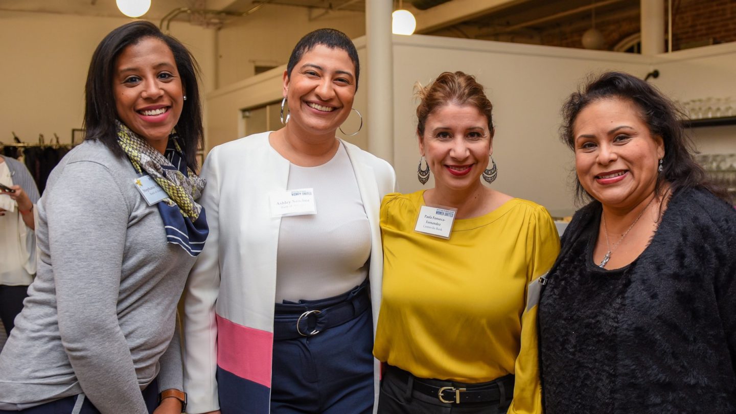 Four smiling Women United members, including (from left to right) Stephanie Pelletier, Ashley Sanchez, and Paola Fonseca-Fernandez.