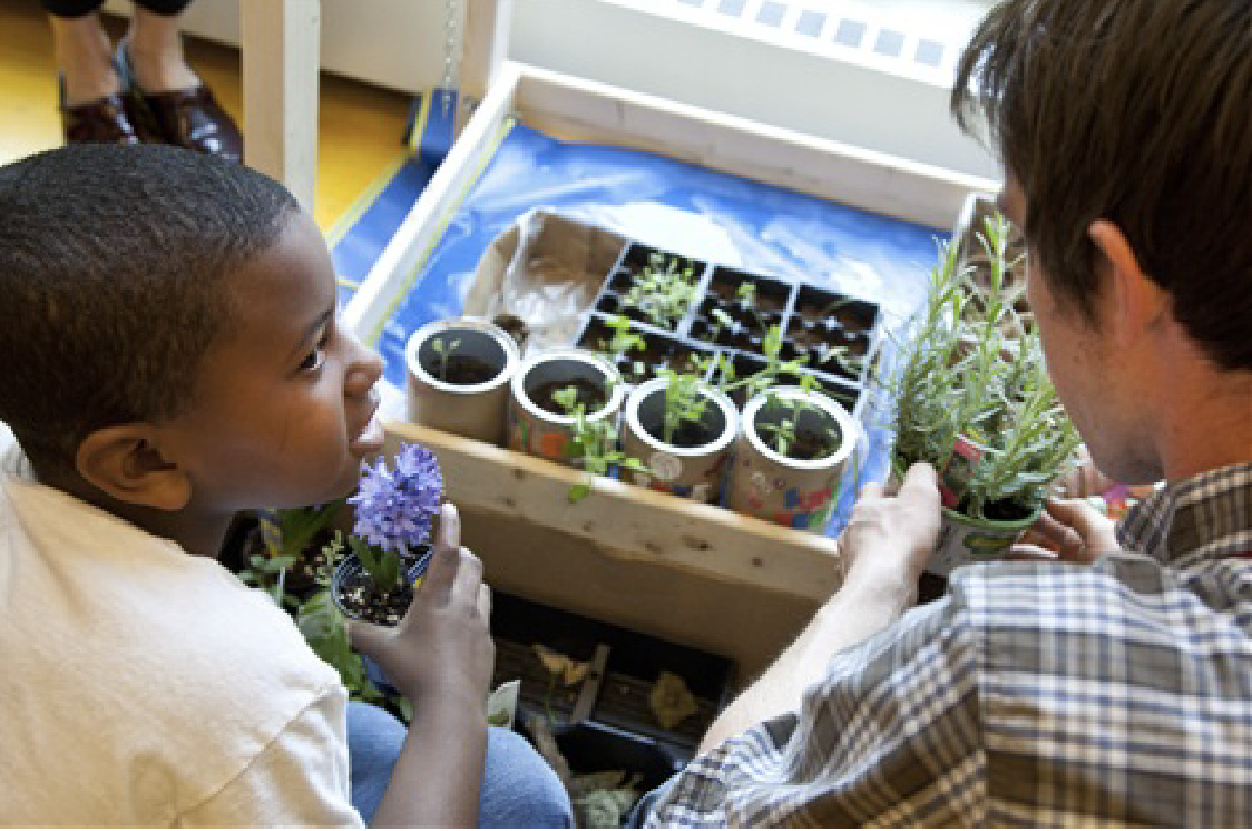 Kid planting seeds inside in a homemade planter