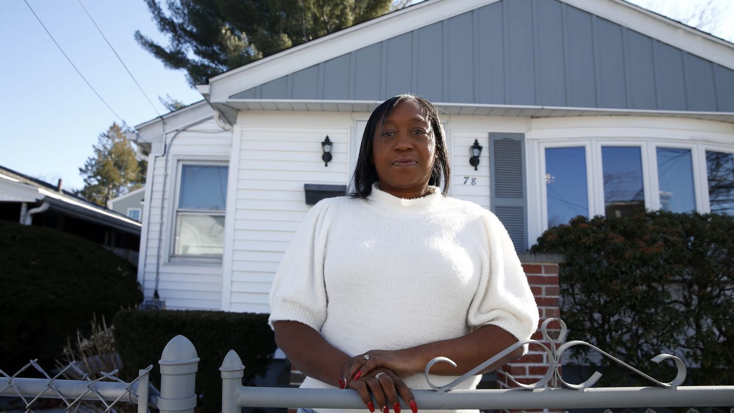 Diana Garlington standing at a fence in front of her home. By JONATHAN WIGGS/GLOBE STAFF