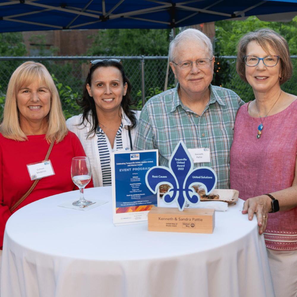 Group of people sitting at table with award