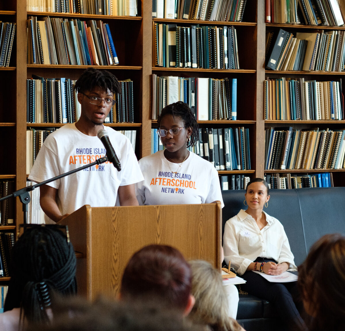 Group of kids in a librarian standing at a podium