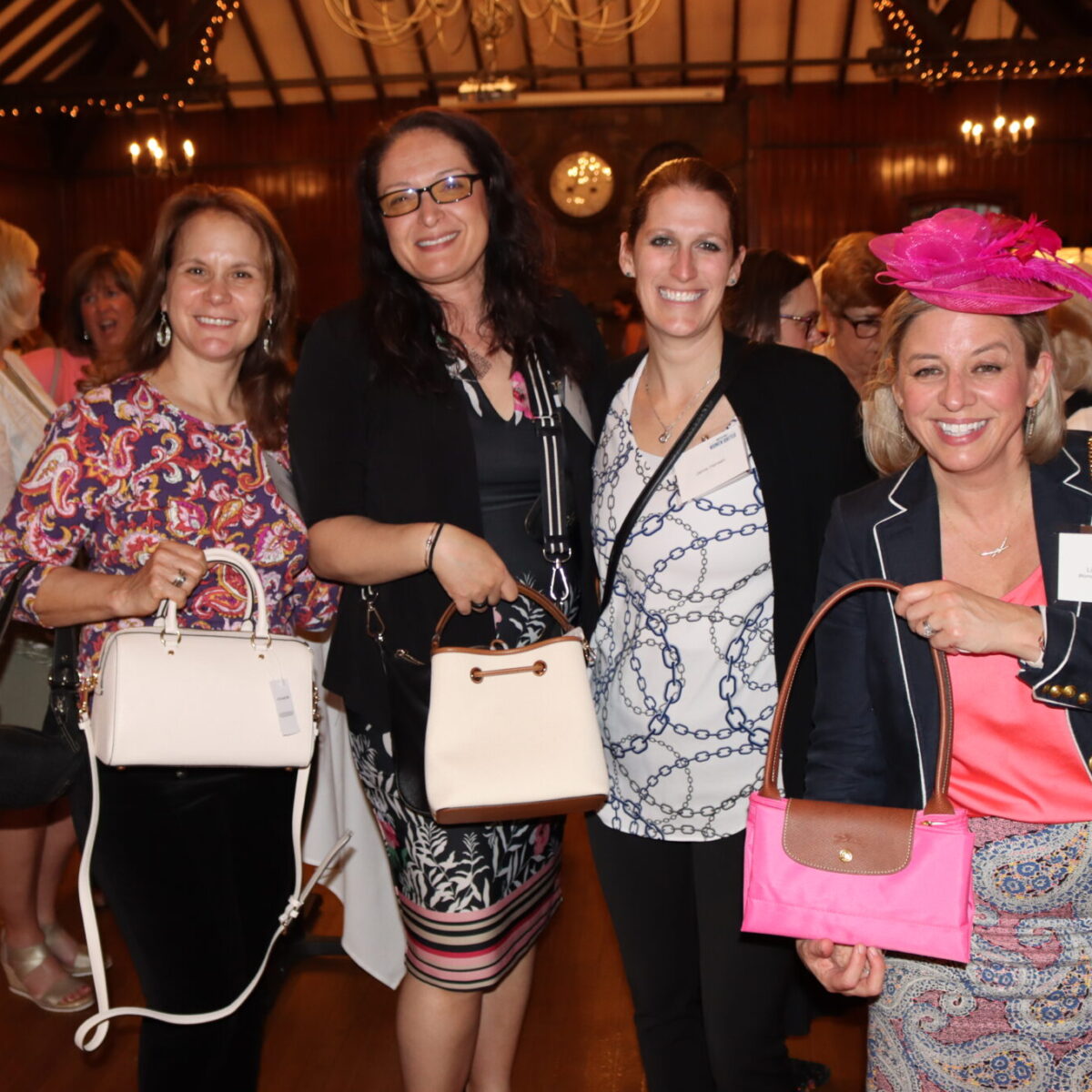 Women United members and friends pose with purses.