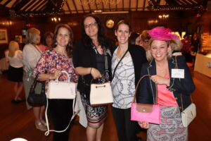 Women United members and friends pose with purses.