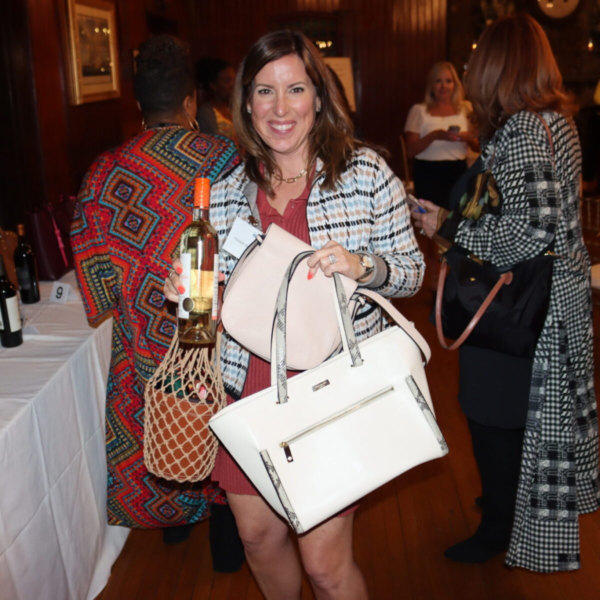 An attendee poses with a purse and a raffle prize.