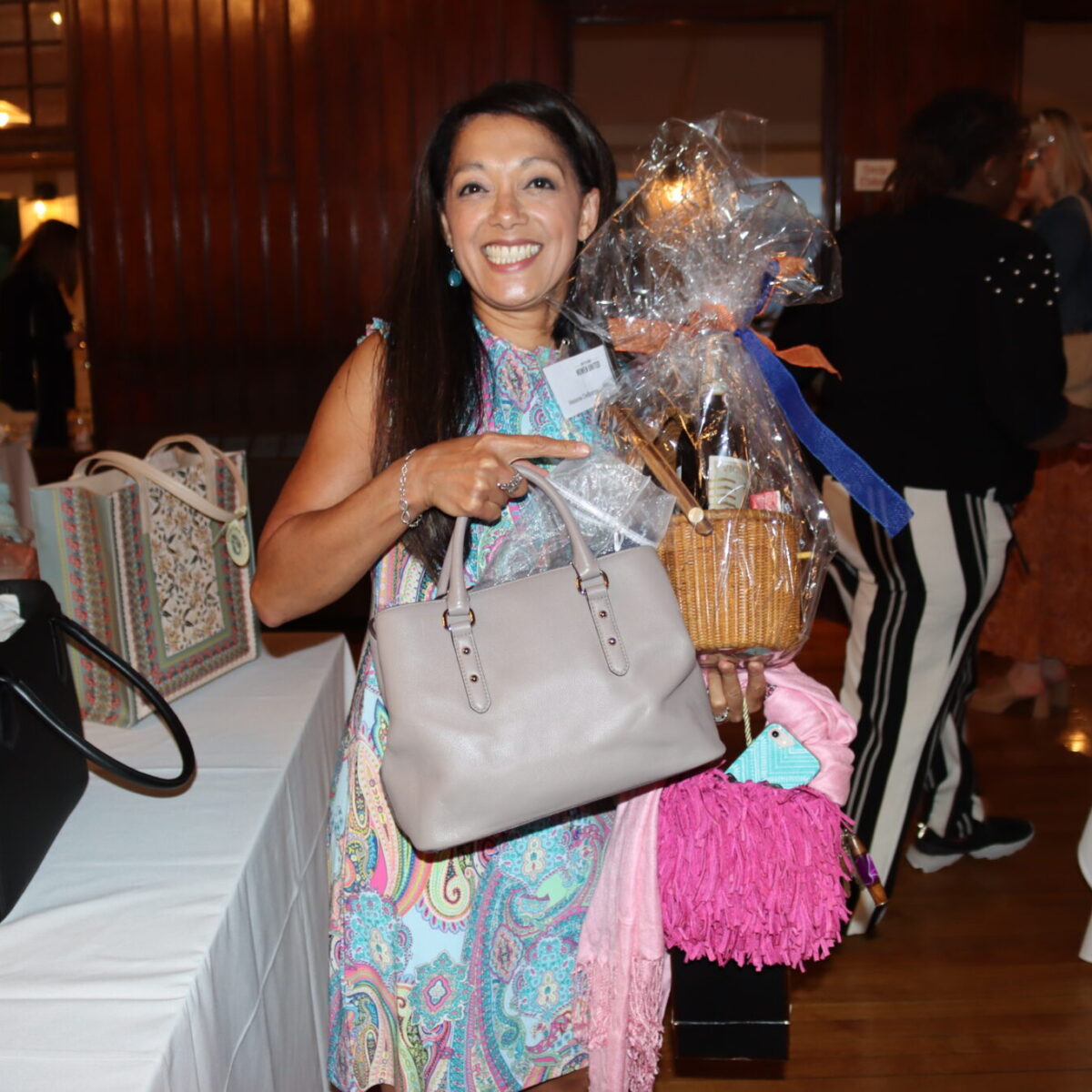 An attendee poses with a purse and a raffle prize.
