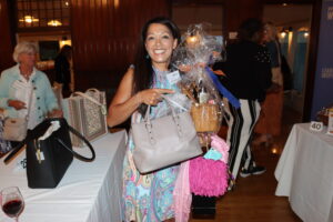 An attendee poses with a purse and a raffle prize.