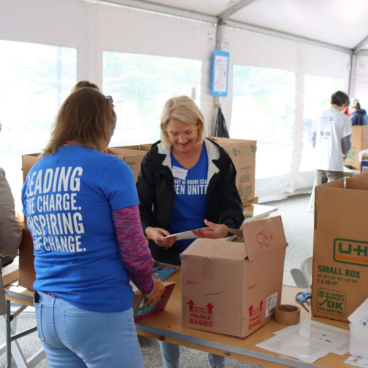 Women United members Anne Ciresi, Ann Goudreau, and MaryKay Koreivo label books.