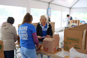 Women United members Anne Ciresi, Ann Goudreau, and MaryKay Koreivo label books.