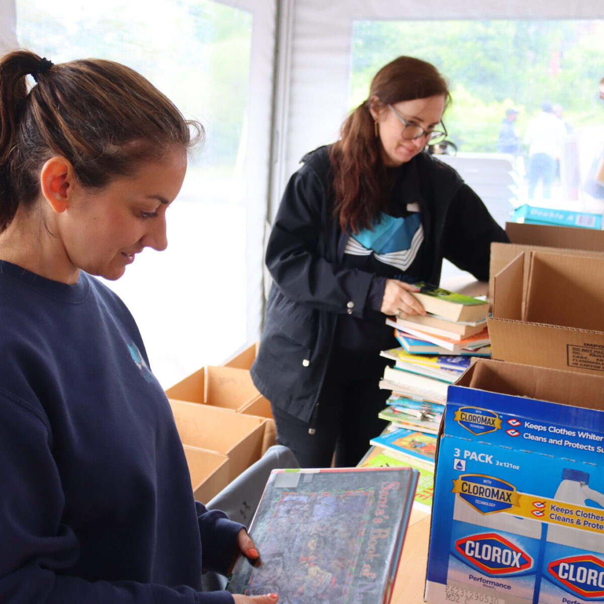 Books Are Wings' Jennifer Smith and Alison Aguiar sort books.