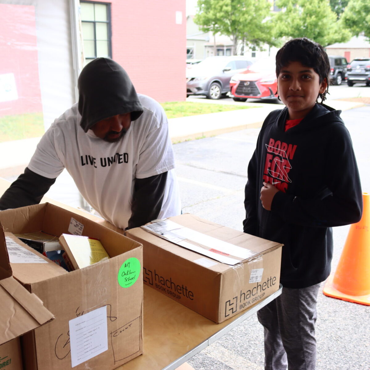 A volunteer poses next to boxes of books.