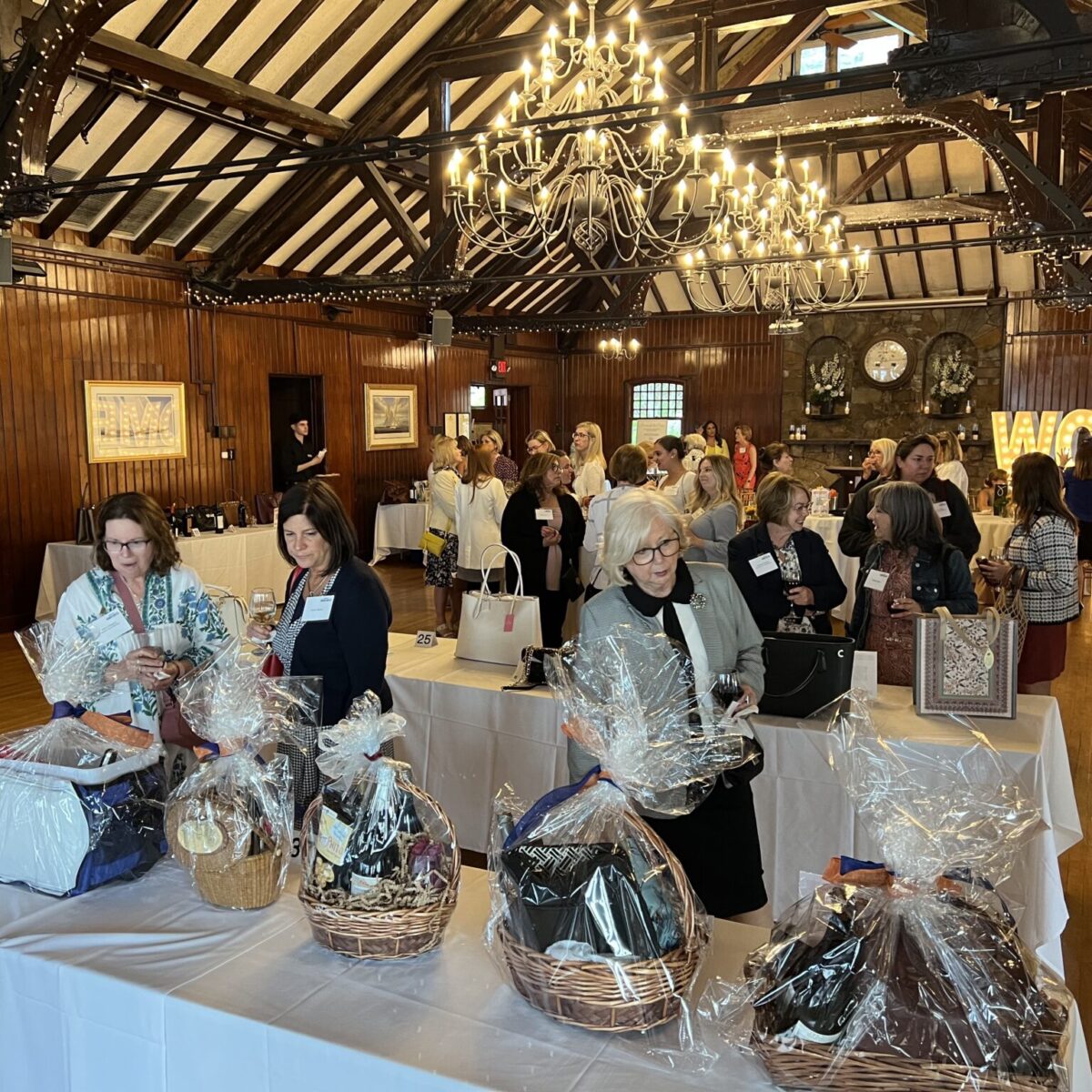 Women United members and friends browse purses in the silent auction.