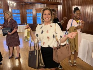 An attendee poses with purses.