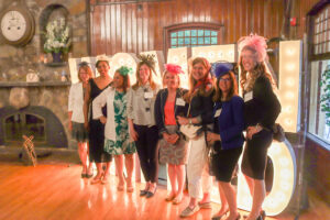 The Women United Membership Committee poses in front of marquee letters.