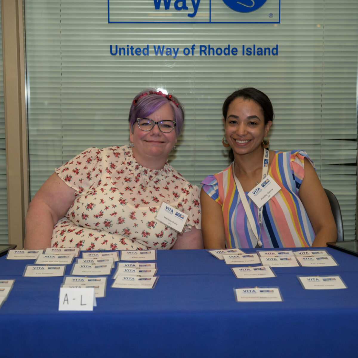 Marlene Guay and Rosilia Guerra pose behind a table with name tags.