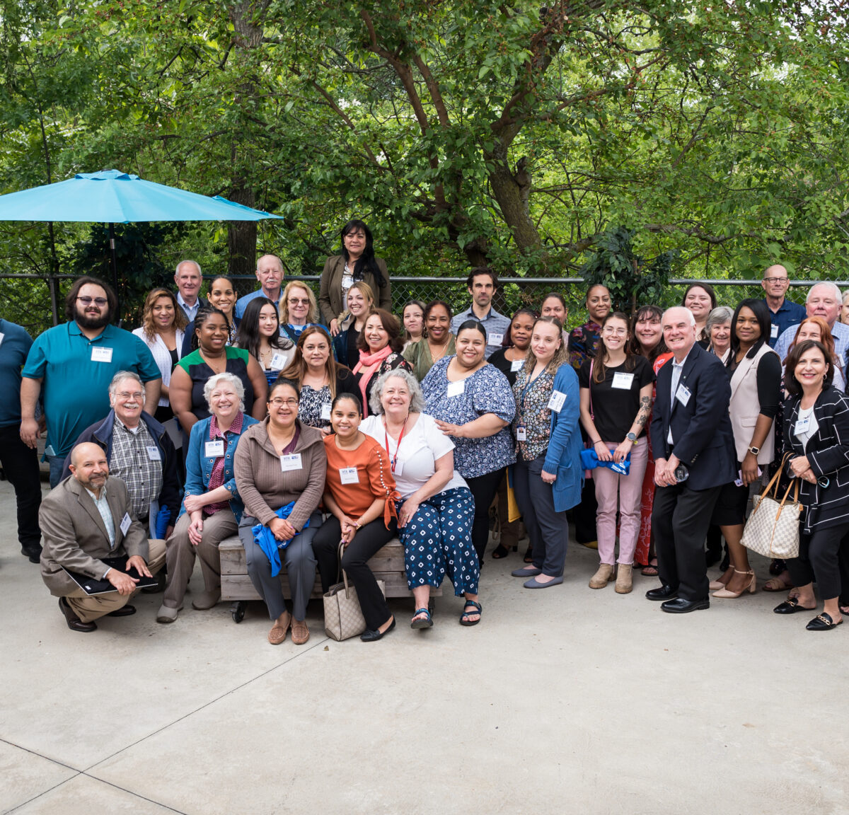 Volunteer Income Tax Assistance volunteers, sponsors, and partners pose in front of trees.