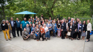 Volunteer Income Tax Assistance volunteers, sponsors, and partners pose in front of trees.
