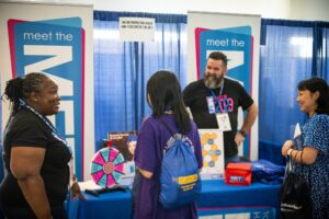 Family talking with representatives from the Met High School.