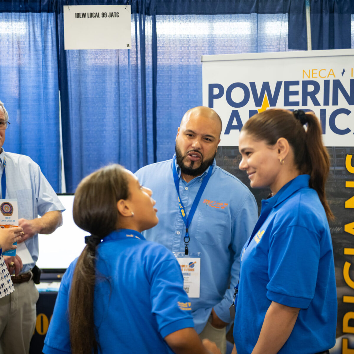 Family talking with representatives from IBEW Local 99.