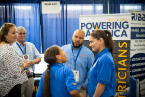 Family talking with representatives from IBEW Local 99.