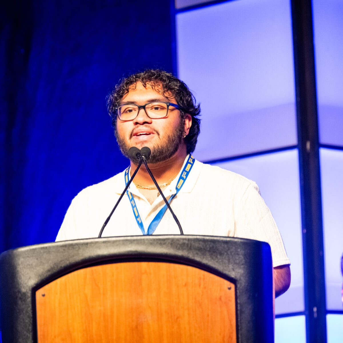 Co-host Marco Antonio Lima speaking from a podium.