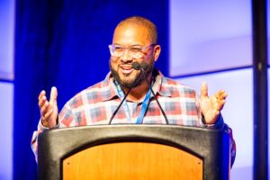 Juan Wilson Jr., founder and CEO of The MUSE Foundation of Rhode Island, speaking from a podium.
