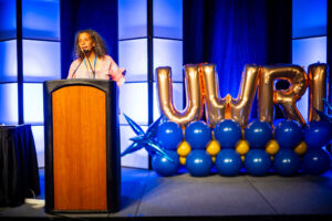 Valerie Tutson, founder and executive director of Rhode Island Black Storytellers, speaking from a podium.
