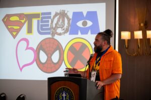 Roberto Gonzalez, executive director of STEAM Box, speaking from a podium.