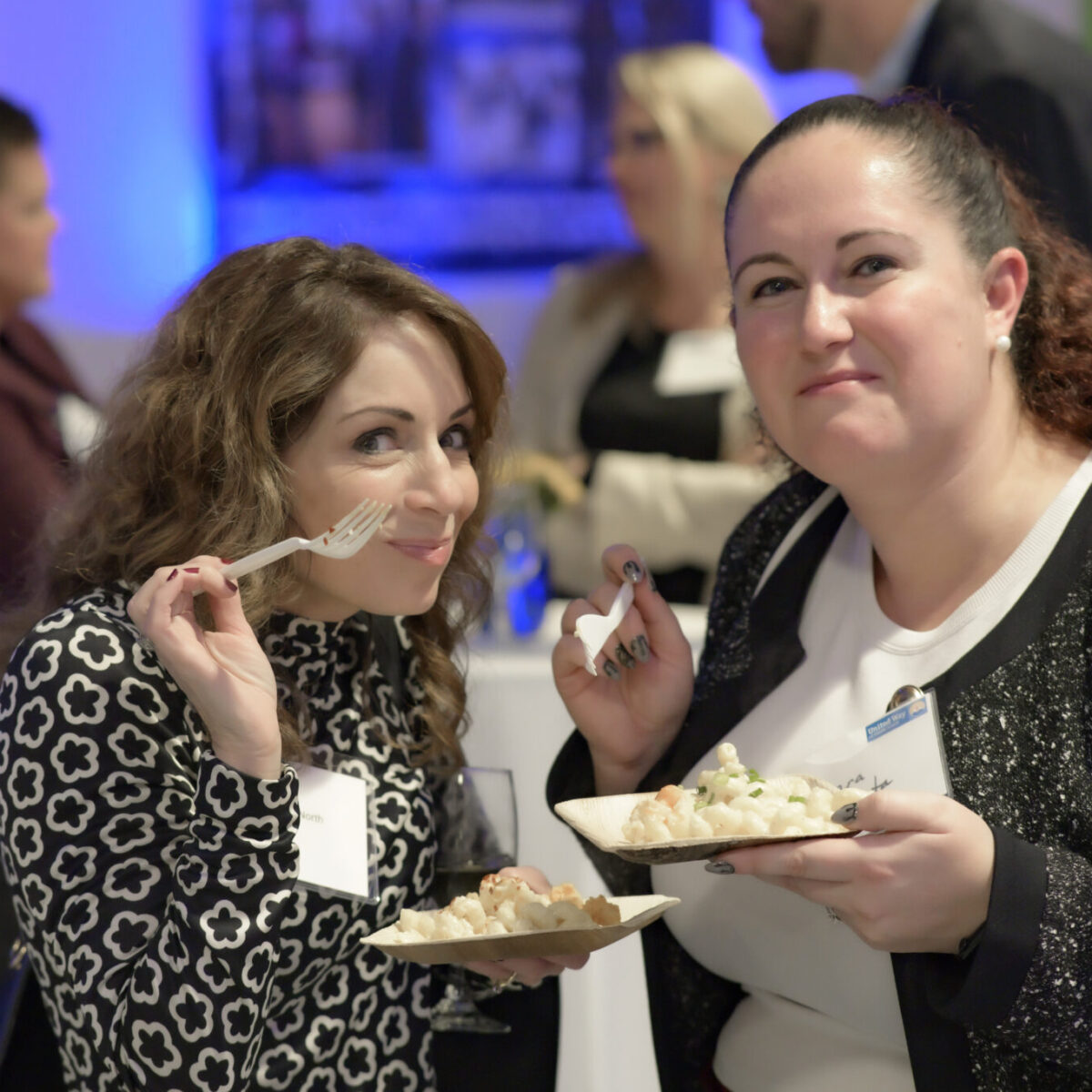 Danielle North and another attendee posing with plates of mac and cheese.