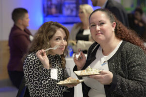 Danielle North and another attendee posing with plates of mac and cheese.
