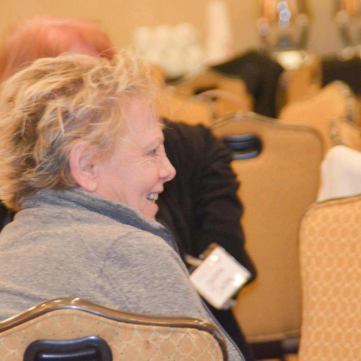 Conference attendee with short blonde hair smiling.