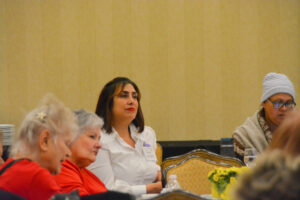 Conference attendee Isabel Escobar sitting at a table with other attendees.
