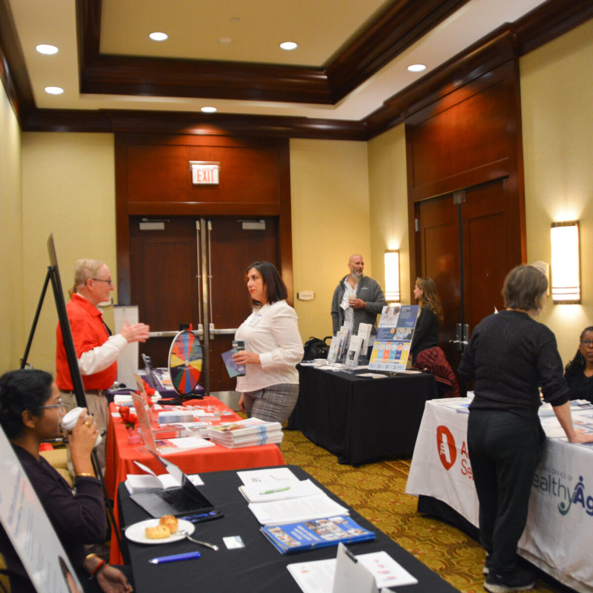 Conference attendees speaking with representatives from local organizations that support healthy aging.