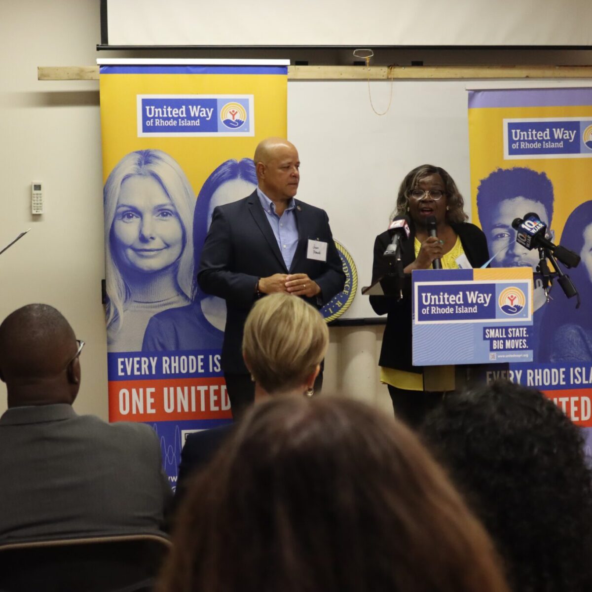 Providence City Councilwoman Mary Kay Harris speaking from a podium alongside Providence City Councilman Juan Pichardo.