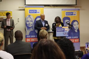 Providence City Councilwoman Mary Kay Harris speaking from a podium alongside Providence City Councilman Juan Pichardo.