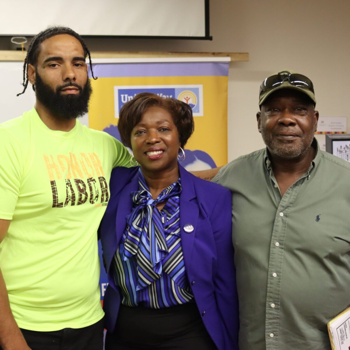 Lisa Ranglin, president and CEO of the Rhode Island Black Business Association, posing with two Black men.