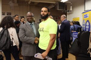 Larry Warner, DrPH, chief impact and equity officer for United Way of Rhode Island, shaking hands with another Black man.