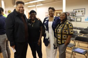 Rodney Davis, chairperson of the Providence Municipal Reparations Commission, posing with three press conference attendees.